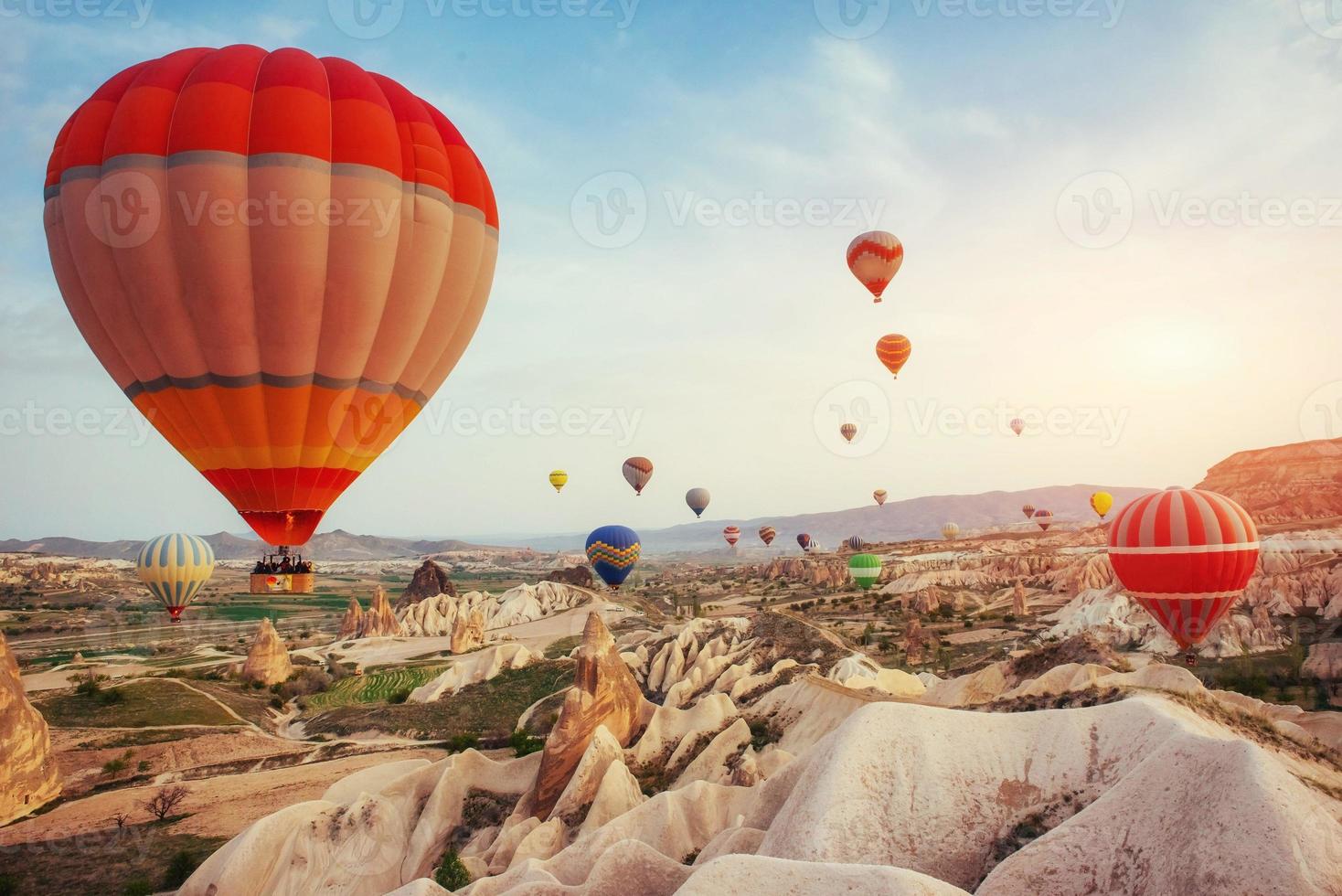 kleurrijke heteluchtballonnen die over rode vallei in cappadocië vliegen, foto