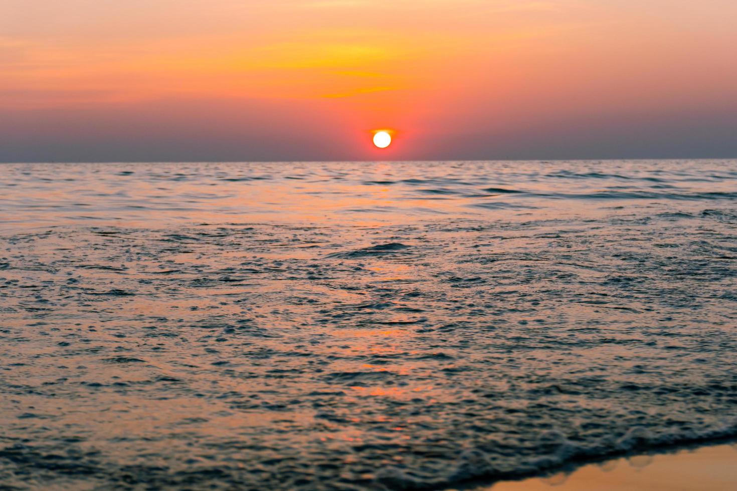 zonsondergang reflectie zee. prachtige zonsondergang achter de wolken en de blauwe lucht boven de overzee landschapsachtergrond foto