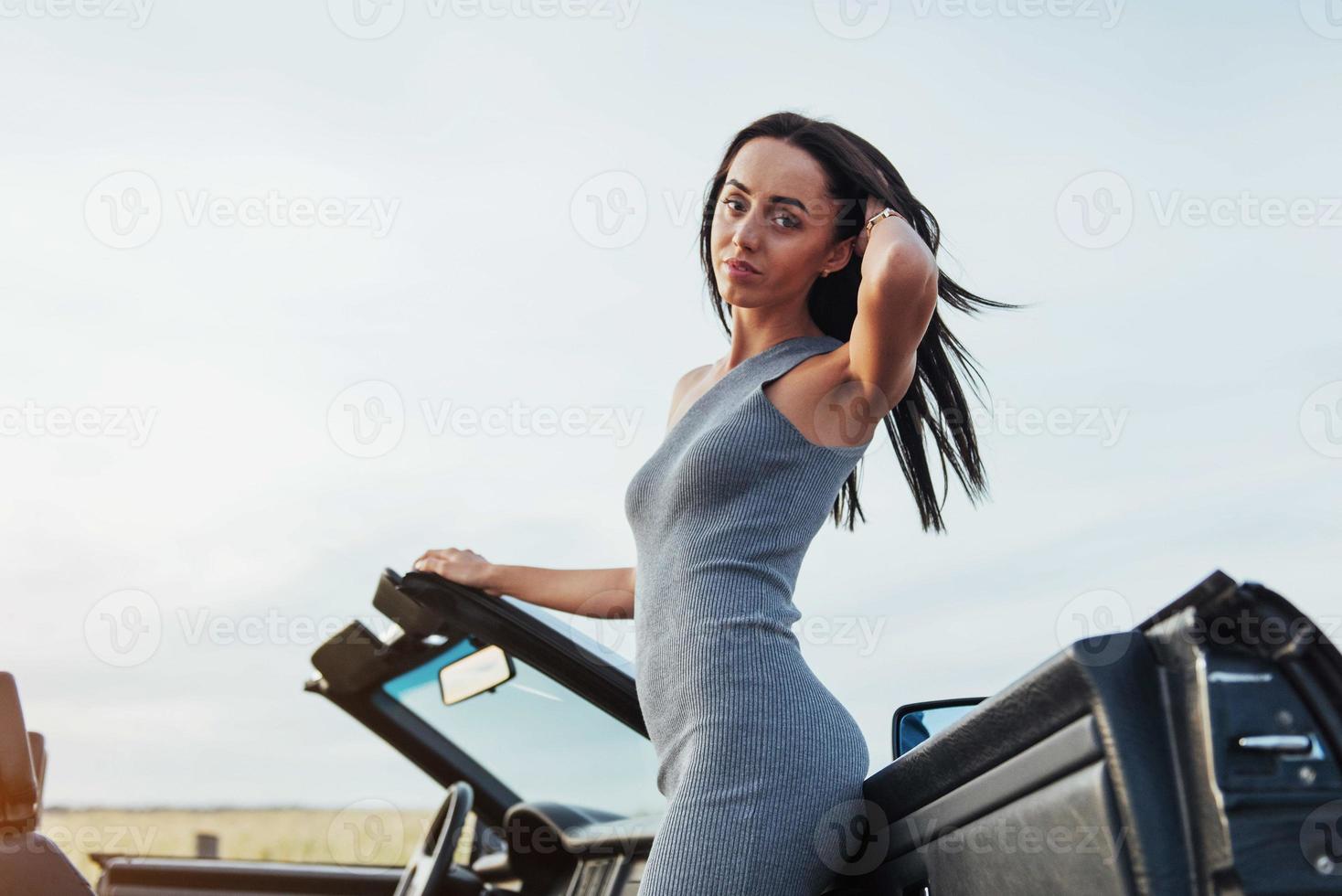 mooie vrouw in de buurt van zwarte cabrio foto