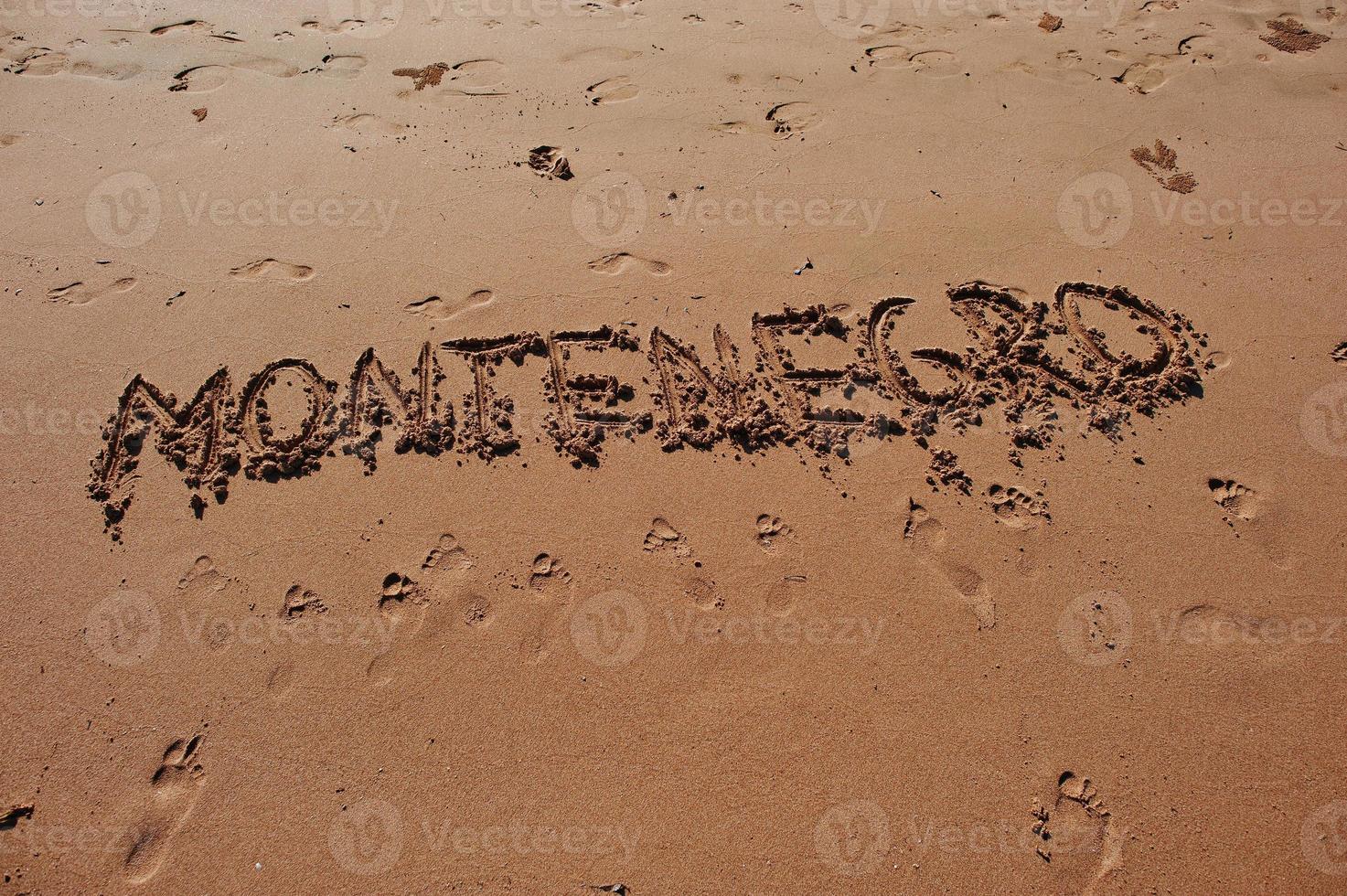 Montenegro geschreven in het zand op het strand foto