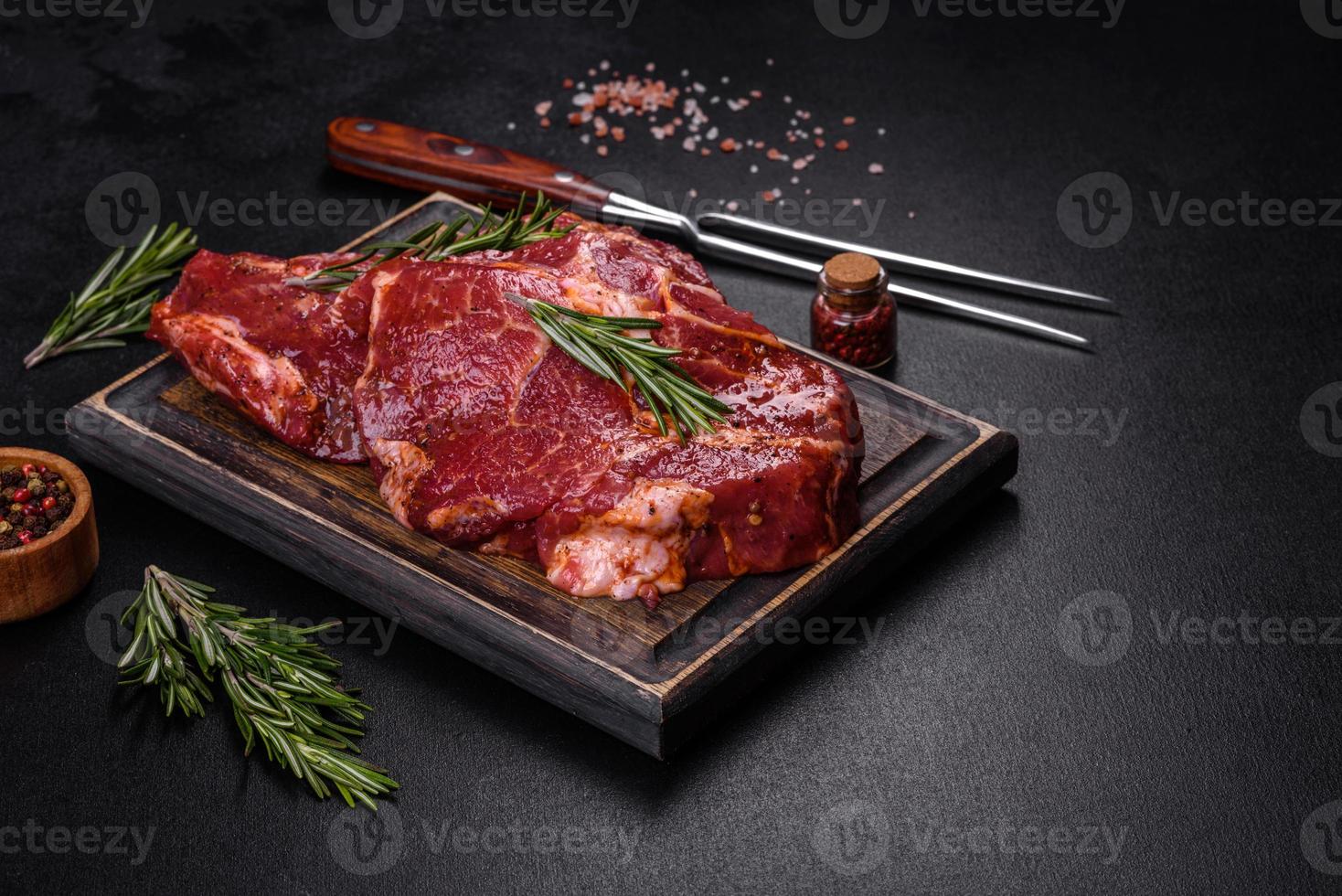 rauwe biologische gemarmerde biefstuk met kruiden op een houten snijplank foto