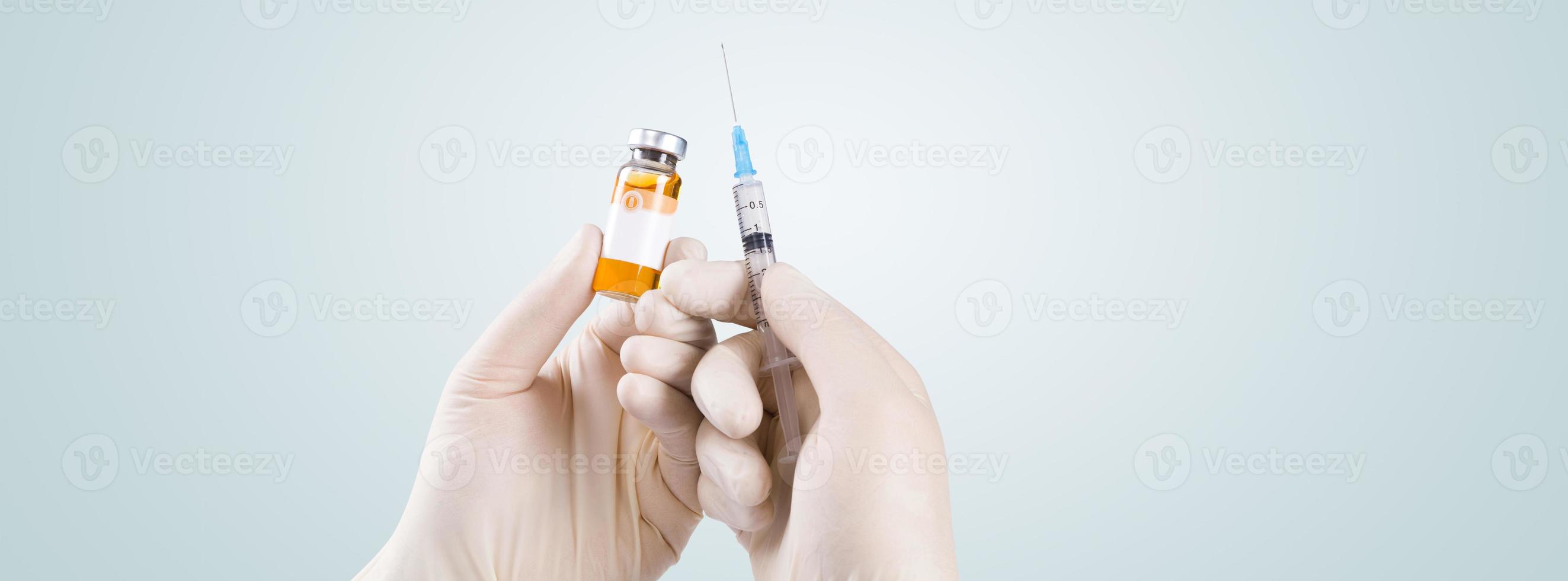 hand met spuit met vaccin tegen corona virus. foto