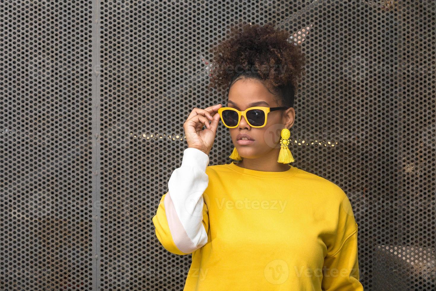 trendy zwarte vrouw in gele zonnebril foto