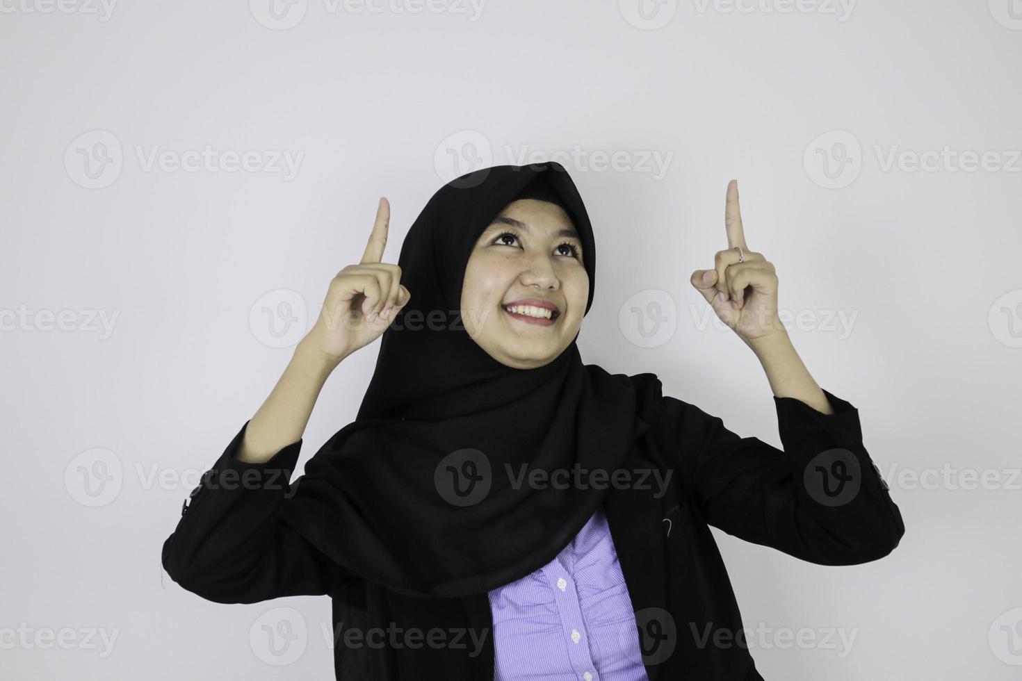 gelukkige Aziatische islamitische zakenvrouwen die hierboven wijzen foto