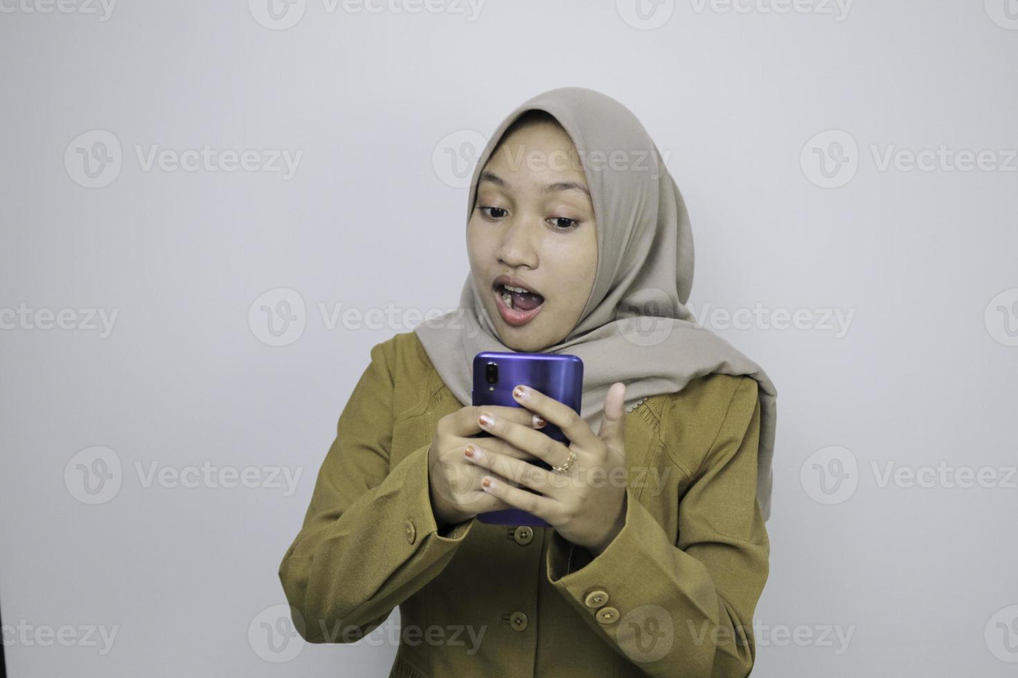 schok regeringswerknemer vrouwen bij het gebruik van een smartphone. pns die een kaki uniform dragen. foto