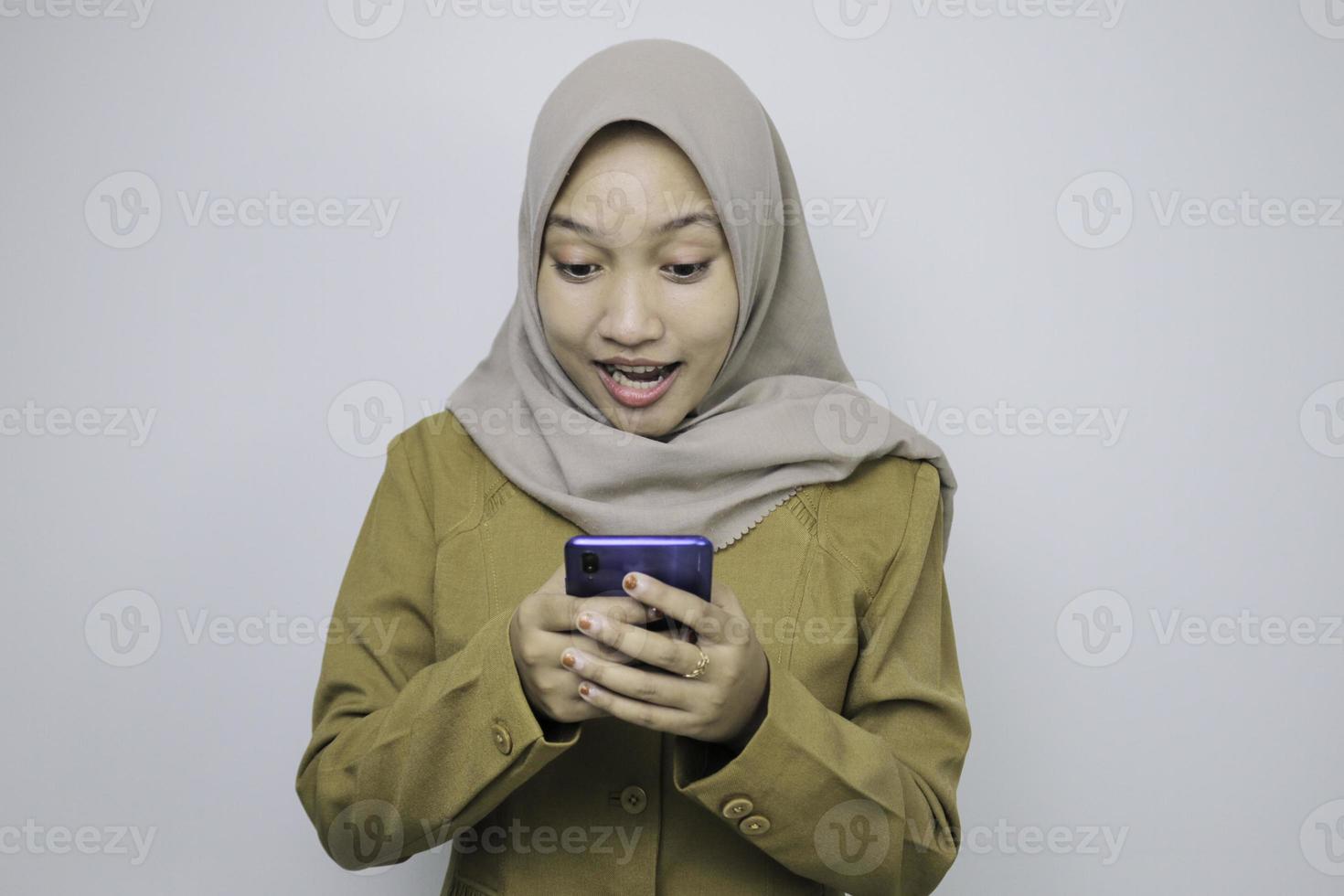schok regeringswerknemer vrouwen bij het gebruik van een smartphone. pns die een kaki uniform dragen. foto