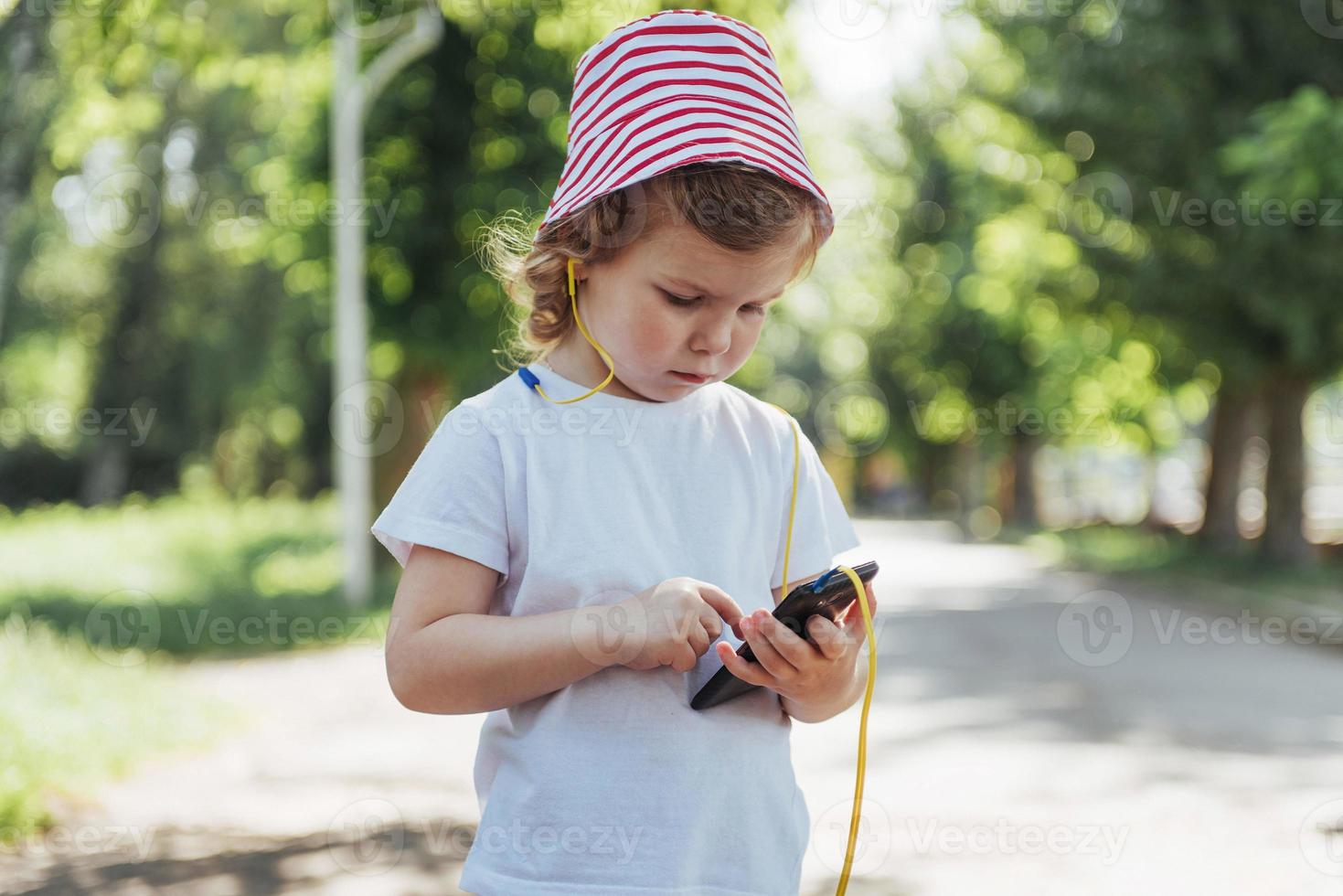 schattig meisje dat buiten naar muziek luistert met een koptelefoon foto