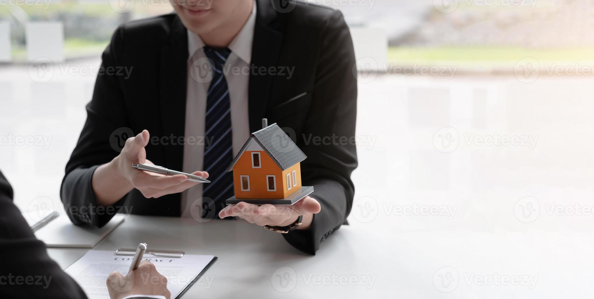 makelaar om huis en land te kopen levert huis aan klant na akkoord te gaan met het maken van een overeenkomst voor de aankoop van een huis. foto