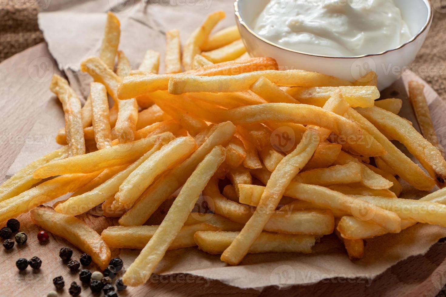 hete gouden frietjes met ketchup op een houten achtergrond. foto