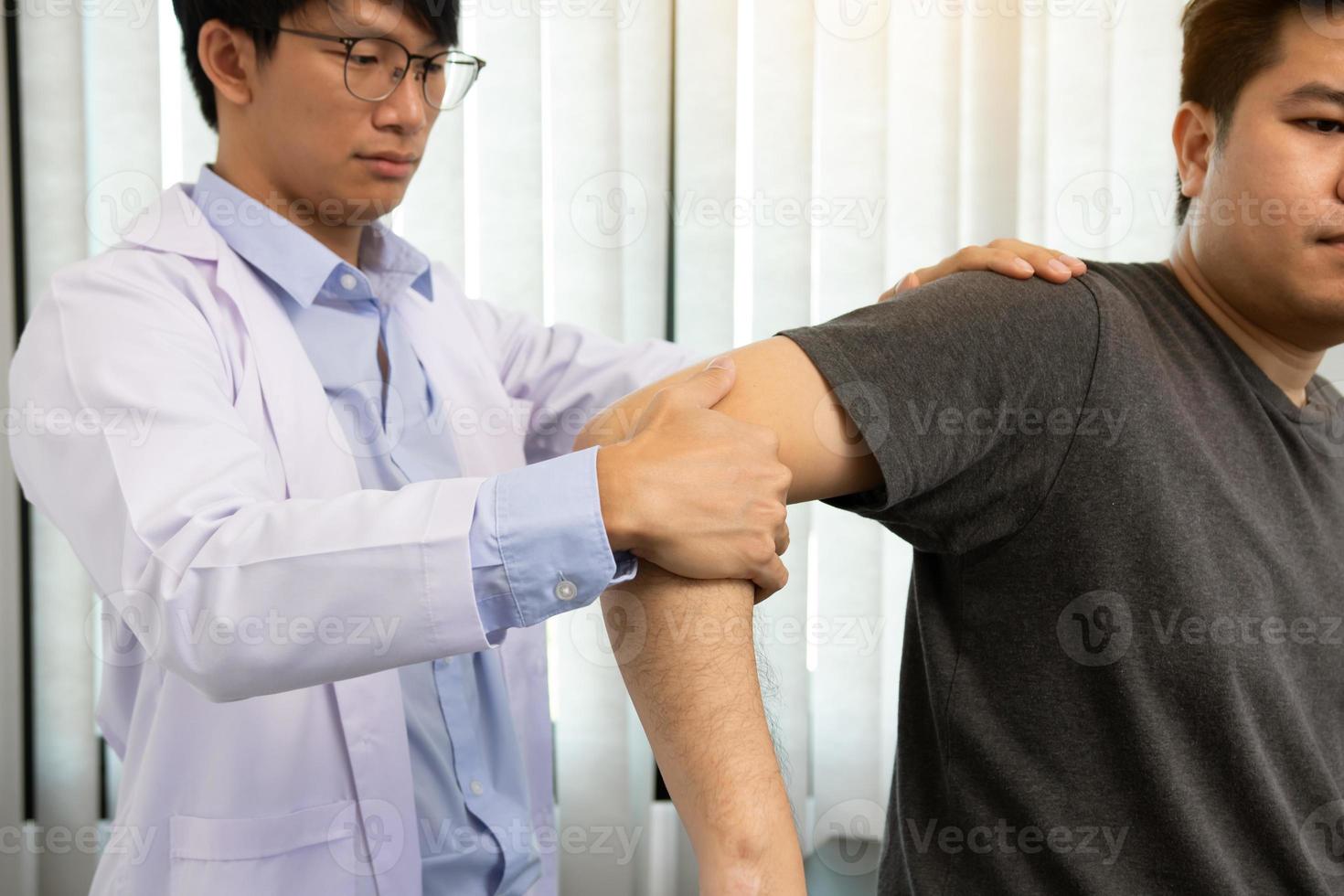 fysiotherapeuten drukken op de schouder van de patiënt om te controleren op pijn. foto
