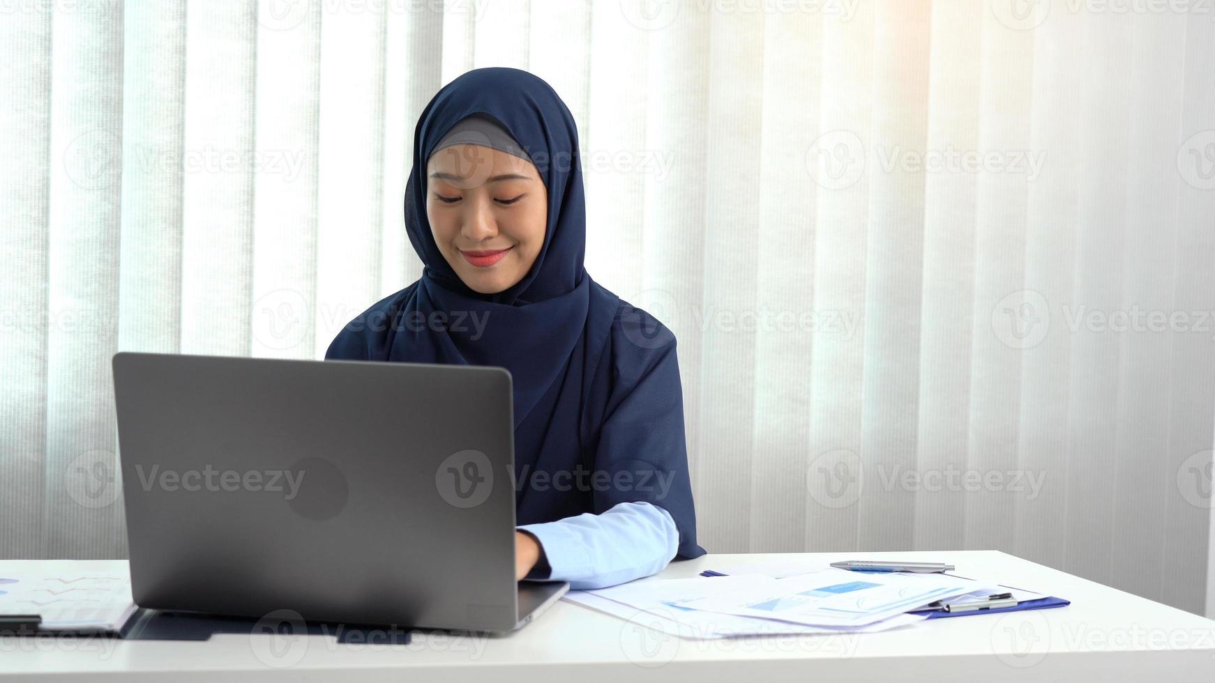 jonge Arabische vrouw zit gelukkig op kantoor. foto