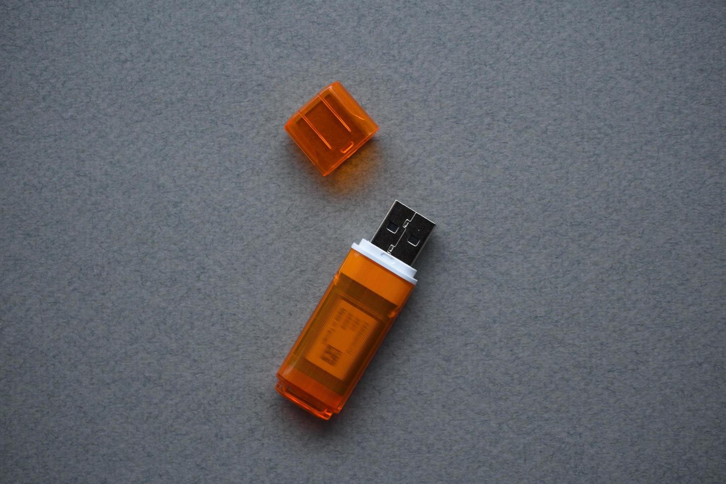 oranje usb-flashkaart op grijze achtergrond foto