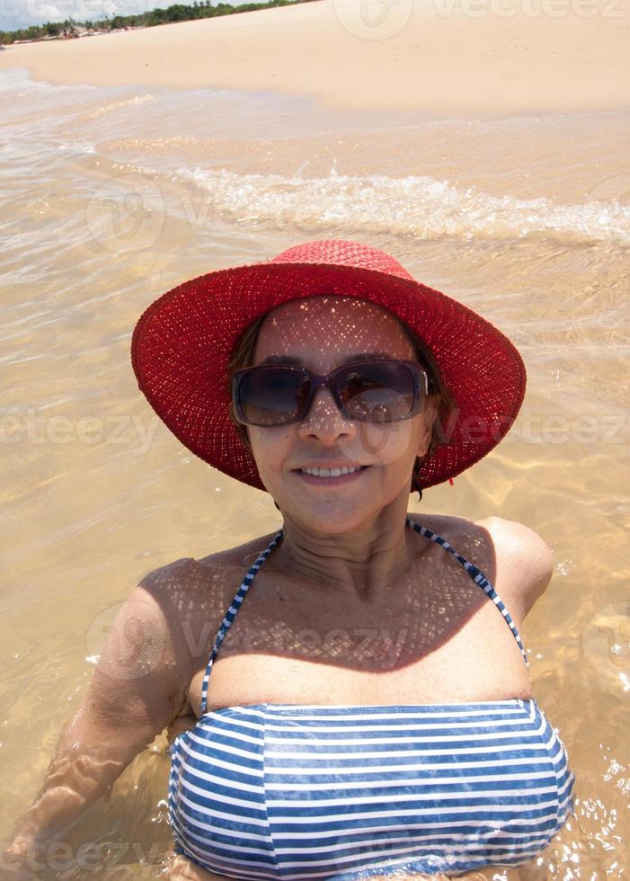 dame geniet van zichzelf op een eenzaam stuk strand in Corumbau, Bahia, Brazilië foto