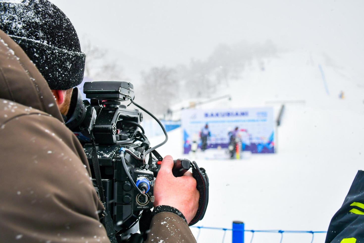 cameraman film skiwedstrijd in skigebied in extreem sneeuwkoude omstandigheden foto