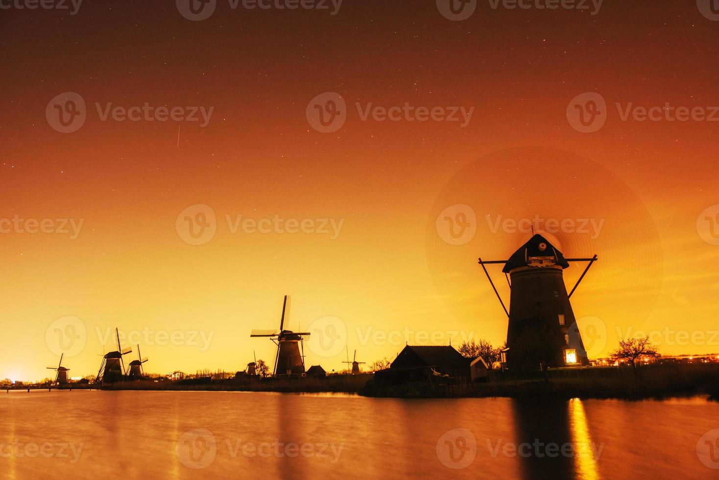 fantastische oranje zonsondergang traditionele Nederlandse windmolens kanaal in rot foto