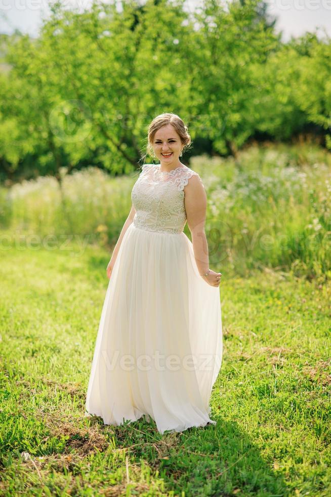 jong overgewicht meisje op beige jurk poseerde achtergrond lentetuin. foto