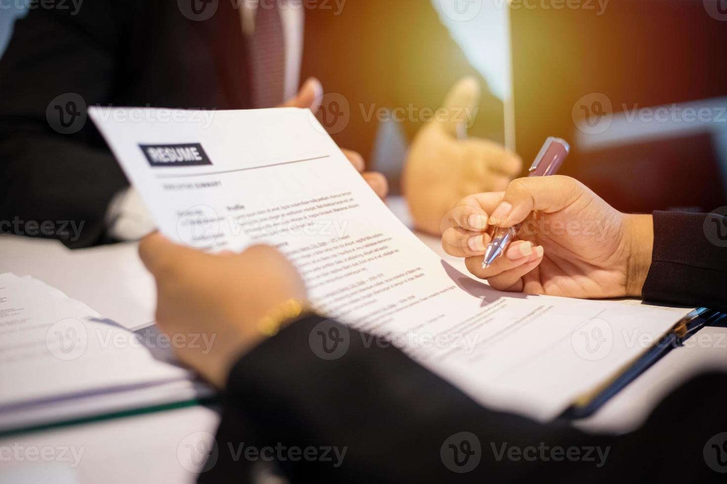 zakenlieden en zakenvrouwen die documenten bespreken en een zakelijke overeenkomst ondertekenen voor het concept van een sollicitatiegesprek foto