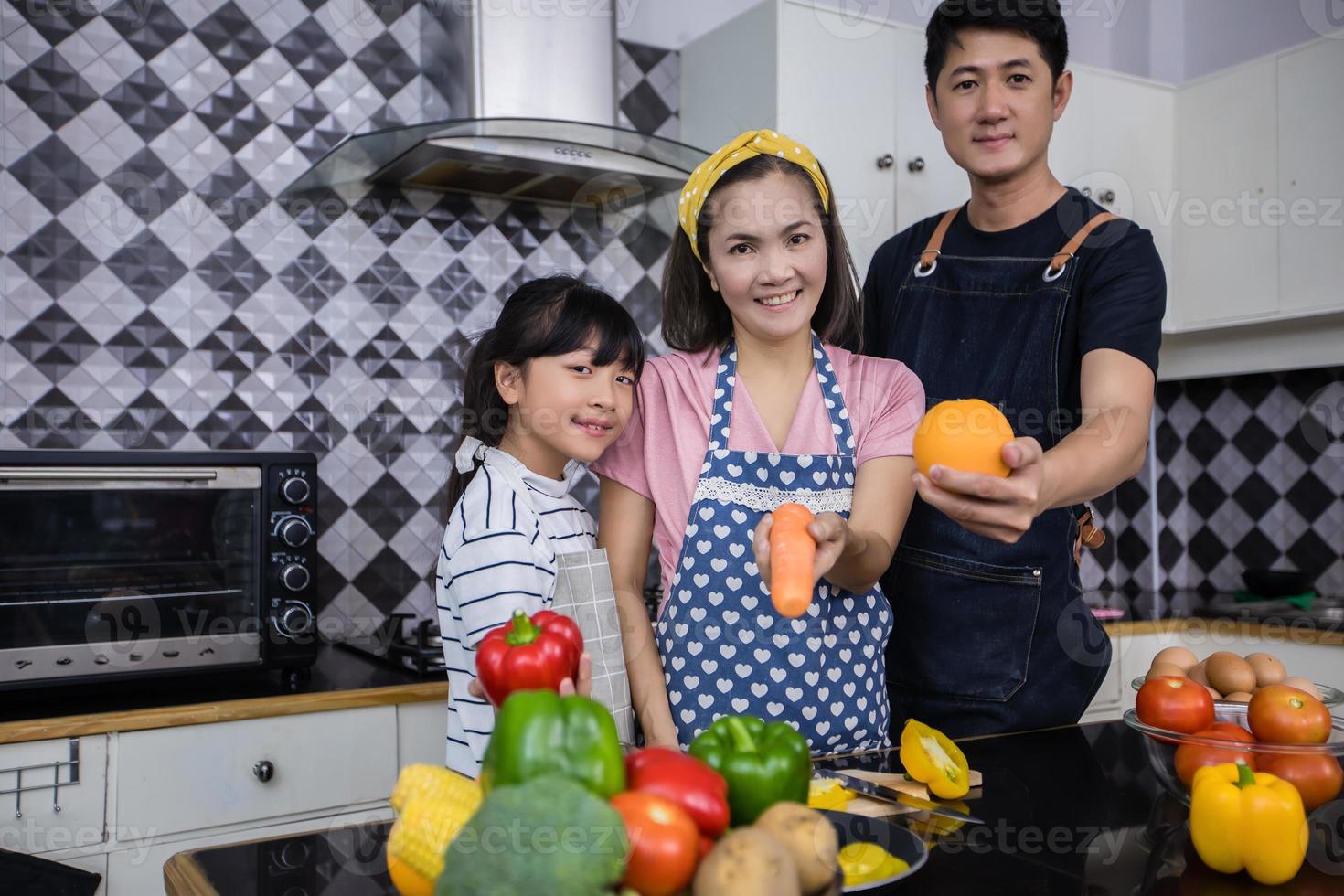 Aziatische gezinnen koken en ouders leren hun dochters om thuis in de keuken te koken. gezinsactiviteiten op vakantie en gelukkig in recreatieconcept foto