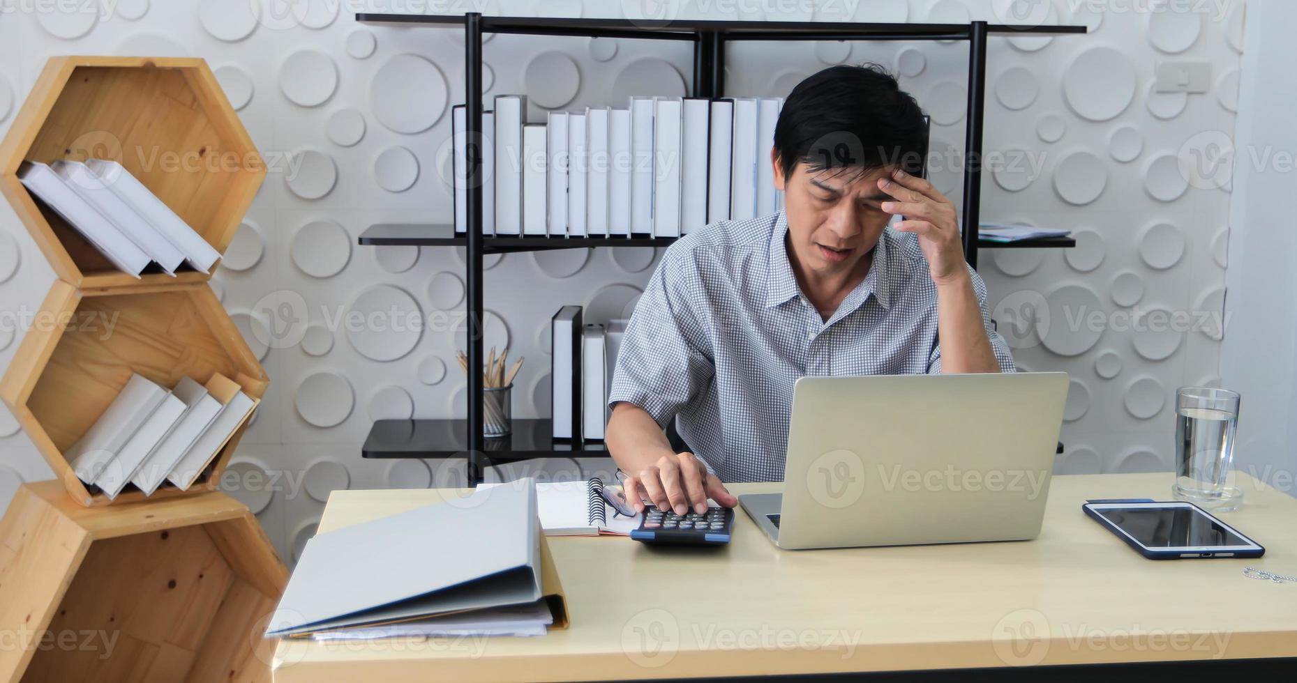 een senior aziatische man die een notebook gebruikt om te werken en een zakenvrouw die serieus is over het werk dat is gedaan tot de hoofdpijn foto