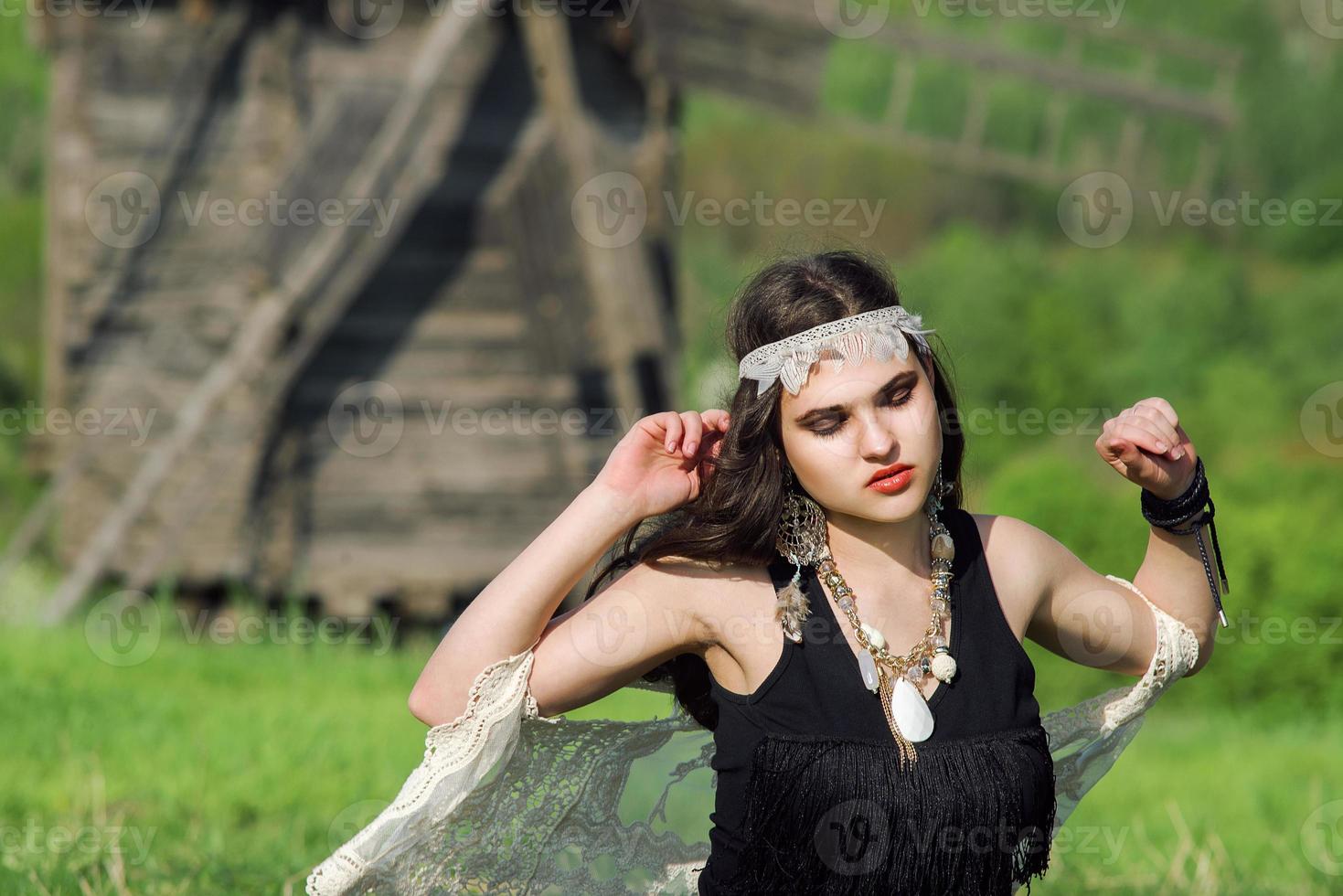 jong mooi meisje met lang donker haar in een groen veld in een etnisch buitendorp in Kiev, Oekraïne foto