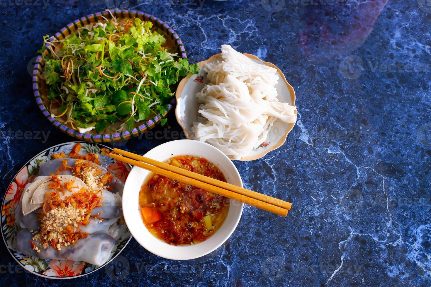 Vietnamees traditioneel eten. kebab rijstnoedels op stenen tafel. broodje cha. bovenaanzicht. foto