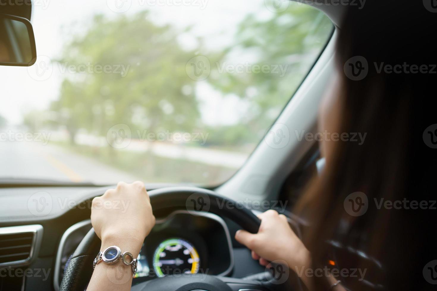 gelukkige aziatische vrouw die het elektrische voertuig bestuurt - ev-auto glimlacht en toont haar duim naar de camera, gelukkig en veilig rijconcept. vrouw moderne ev auto rijden en glimlacht naar de camera. foto