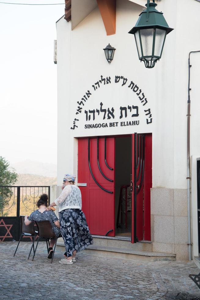belmonte, portugal- 08132021-de sinagoge van bet eliahu is een belangrijk oriëntatiepunt in belmonte. twee vrouwen wachten voor de hoofdingang. foto