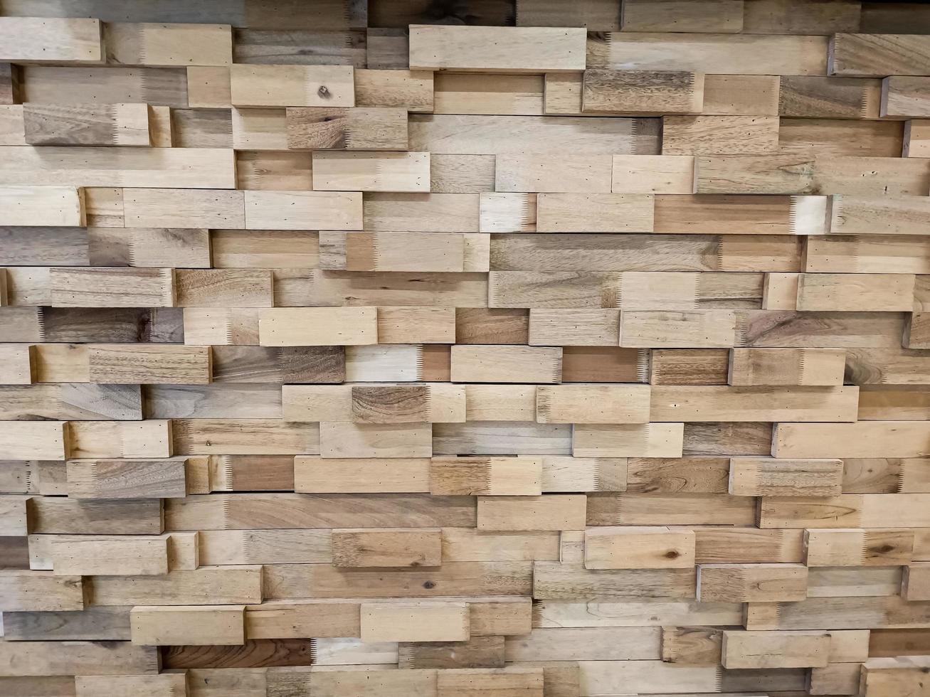 bruin zichtbare houten muur buitenkant, patchwork van onbewerkt hout dat een prachtig parkethoutpatroon vormt. foto