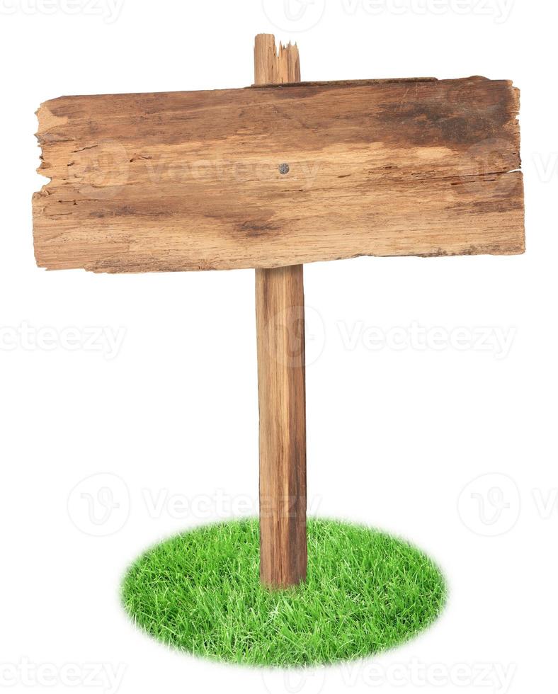 oud houten teken op het gras dat op witte achtergrond wordt geïsoleerd foto