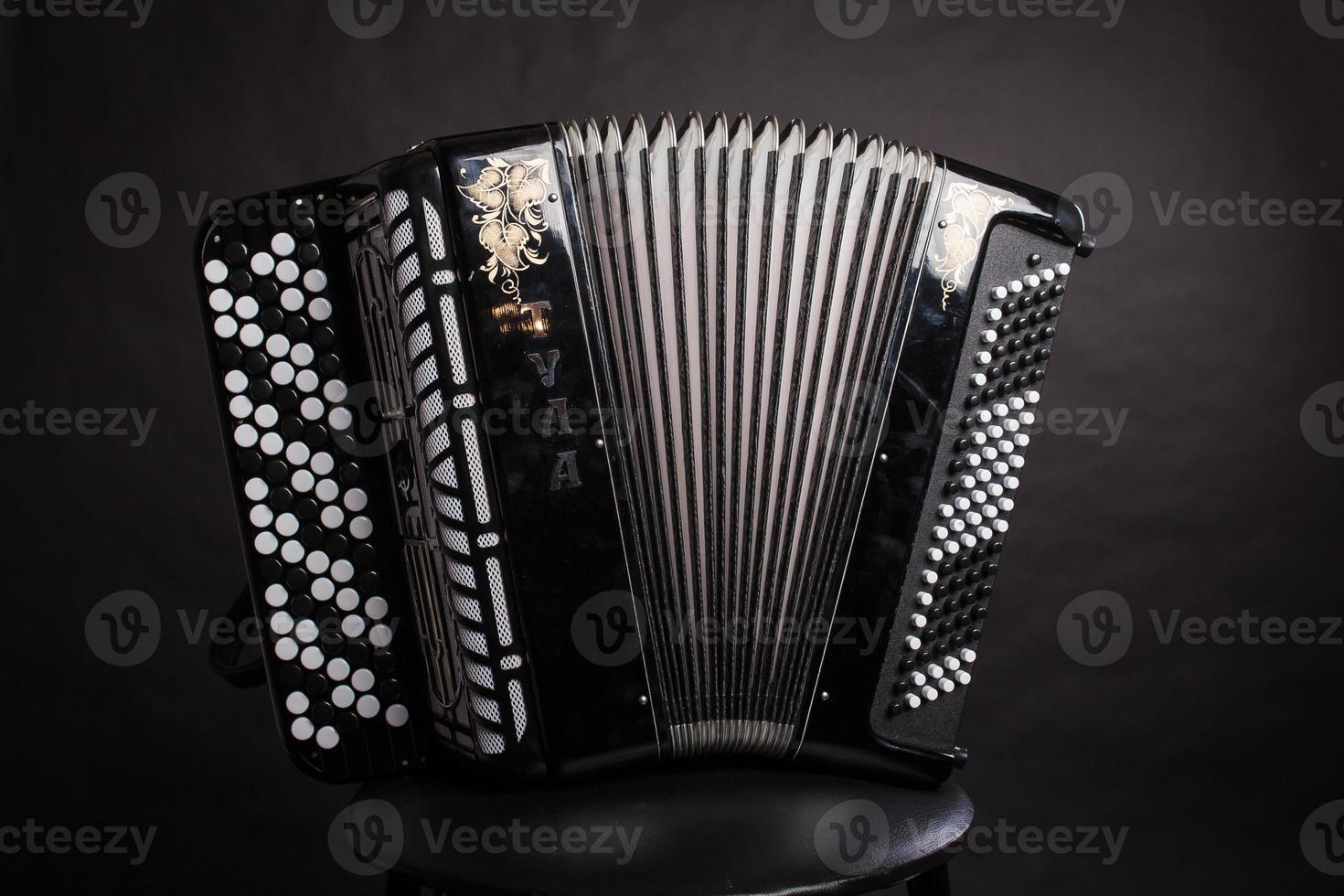 Russische volksmuziekinstrumenten.zwarte accordeon geïsoleerd op een donkere achtergrond foto