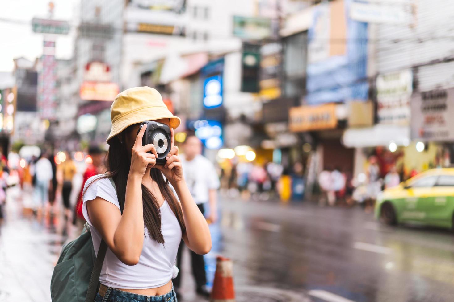 Aziatische reizigersvrouw met camera bij Chinatown. foto