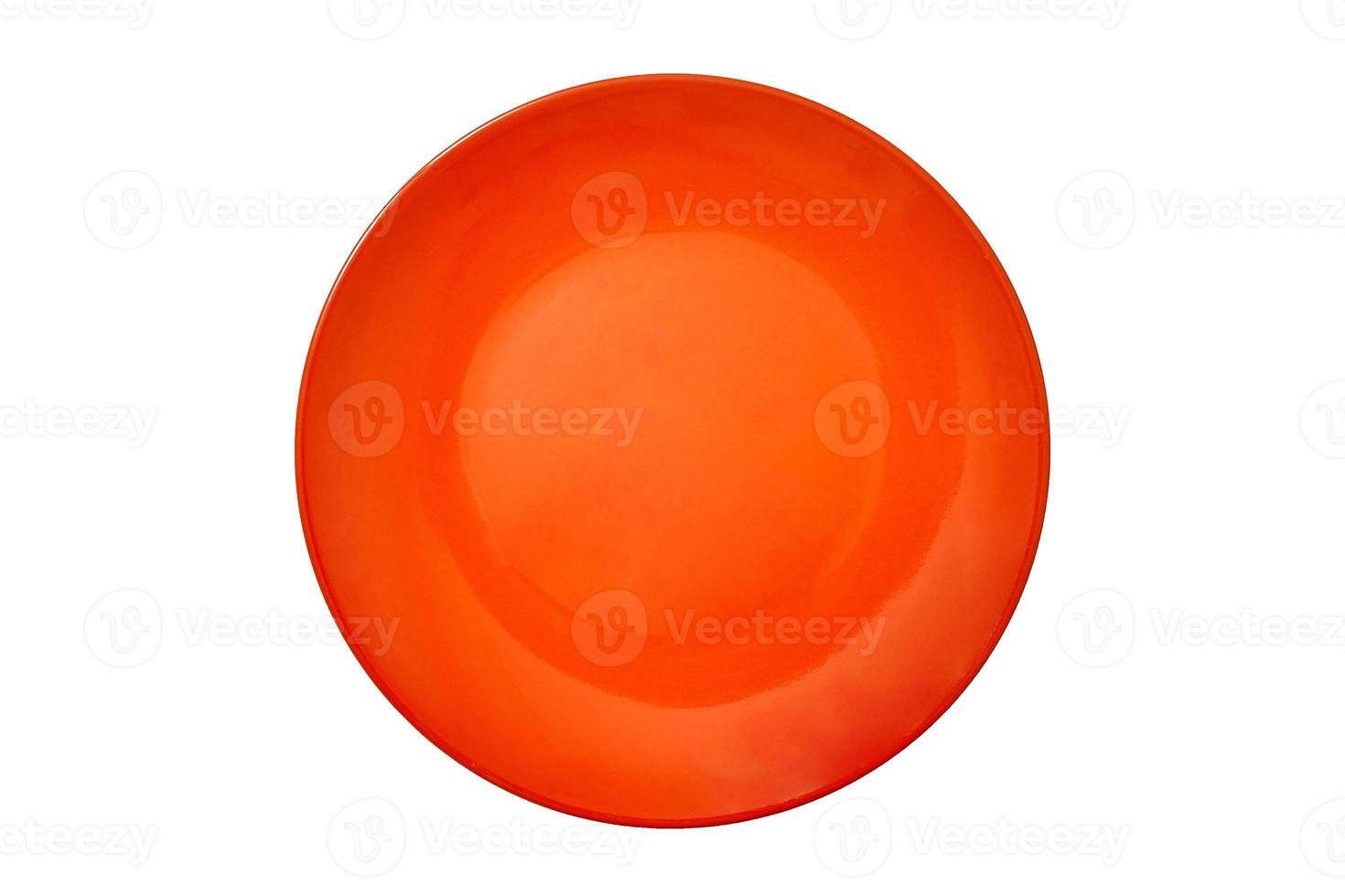 een lege grote ronde keramische plaat van fel oranje kleur voor voedsel op een witte geïsoleerde achtergrond wordt gefotografeerd vanuit het bovenaanzicht. conceptlay-out voor etikettering en voedselplaatsing. model. plat liggen. foto