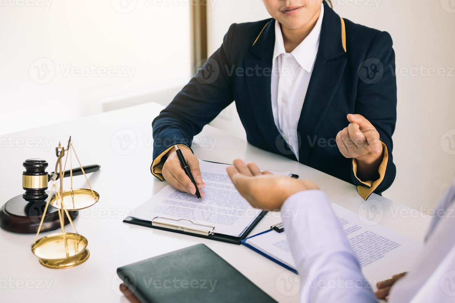 juridisch adviseur legt het misdrijf onder de wet in het boek op kantoor uit. foto