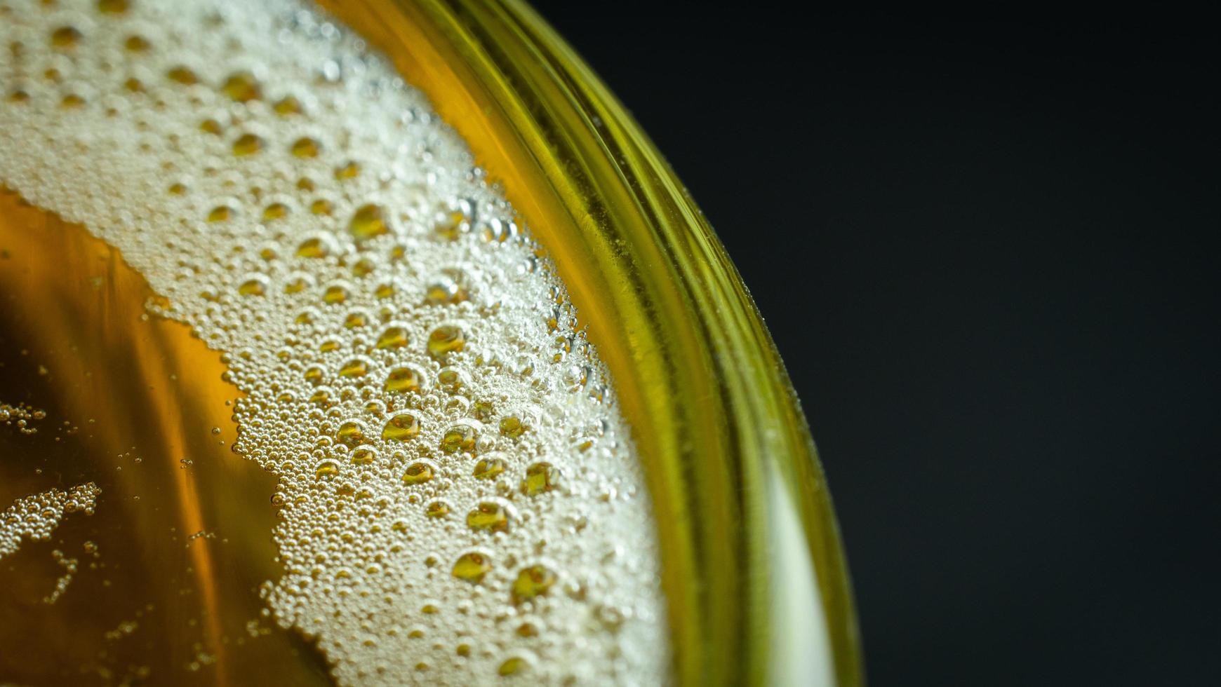 luchtbellen of schuim op de voorkant van het bier in het glas. het bierglas heeft water en belletjes aan de rand van het glas. foto
