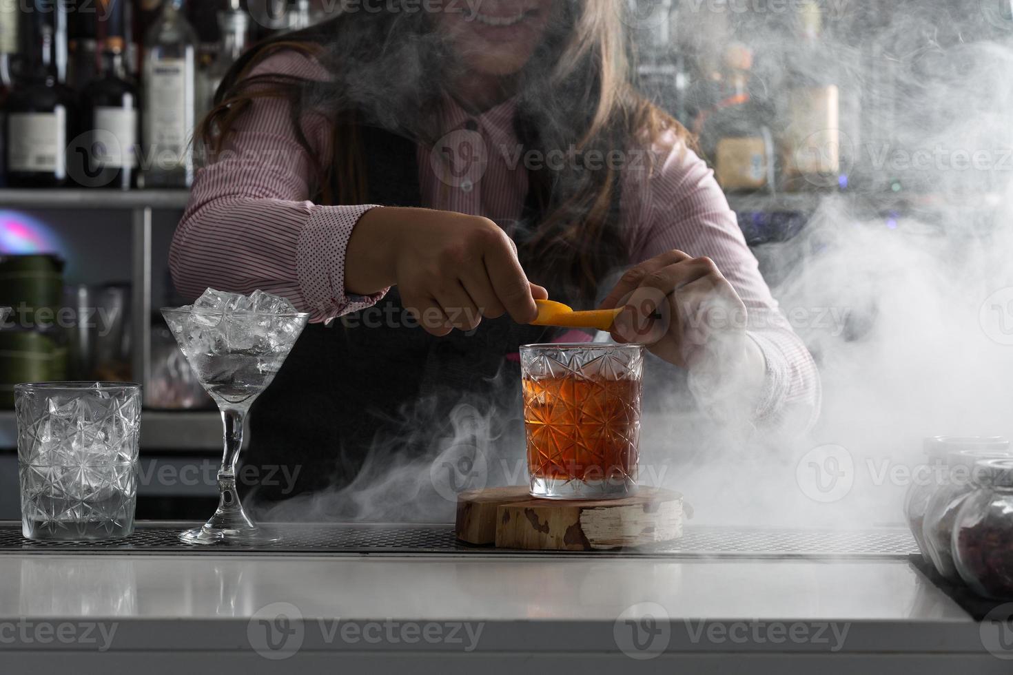 barkeeper serveert cocktail aan toog foto