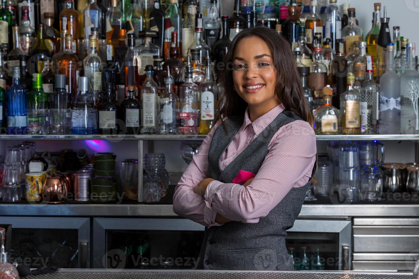zelfverzekerde Spaanse vrouw die in bar werkt foto
