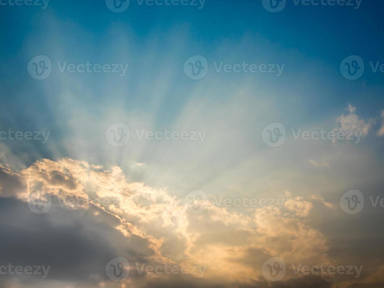 zonnestraal van de zon achter de wolken foto