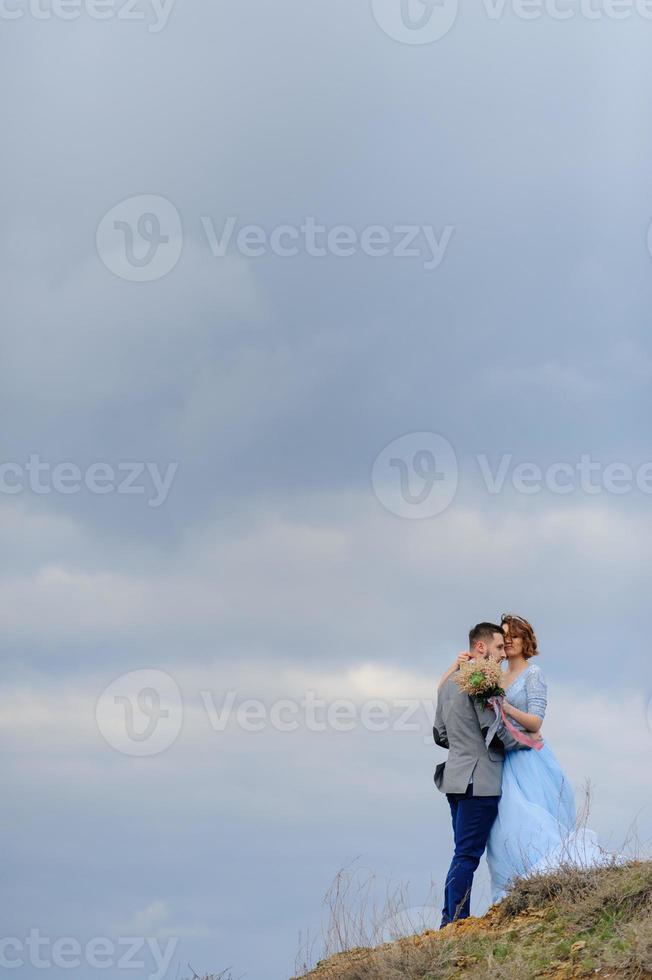 bruiloft fotosessie van een paar aan de kust. blauwe trouwjurk op de bruid. foto