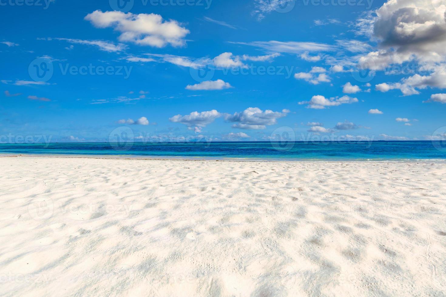 close-up van zand op het strand en de blauwe zomerhemel. panoramisch strandlandschap. leeg tropisch strand en zeegezicht. blauwe lucht, zacht zand, kalmte, rustig ontspannend zonlicht, zomerstemming. reis vakantie foto