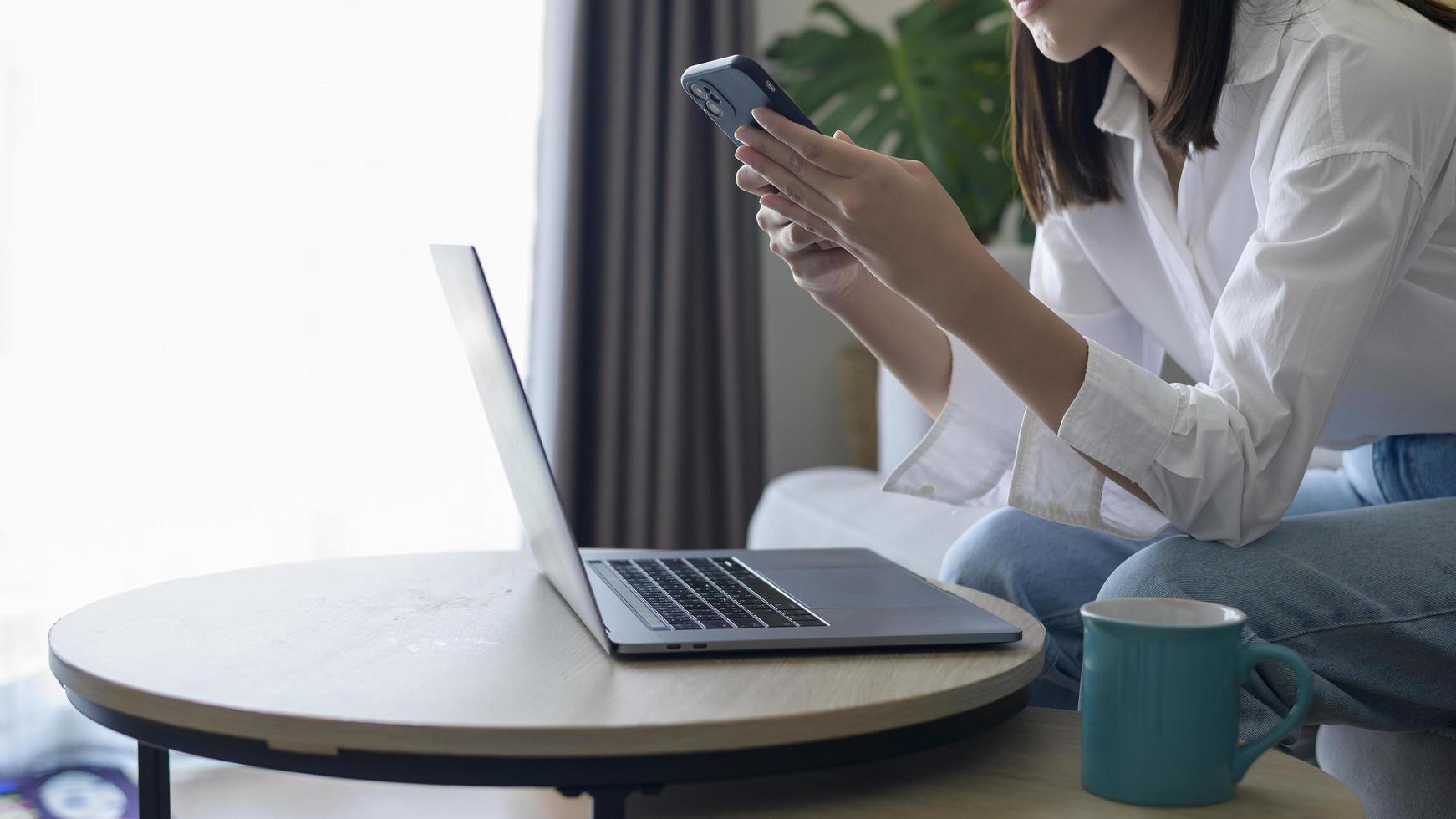 jonge gelukkige vrouw ontspannen en het gebruik van slimme telefoon thuis, sociale media en technologie concept. foto