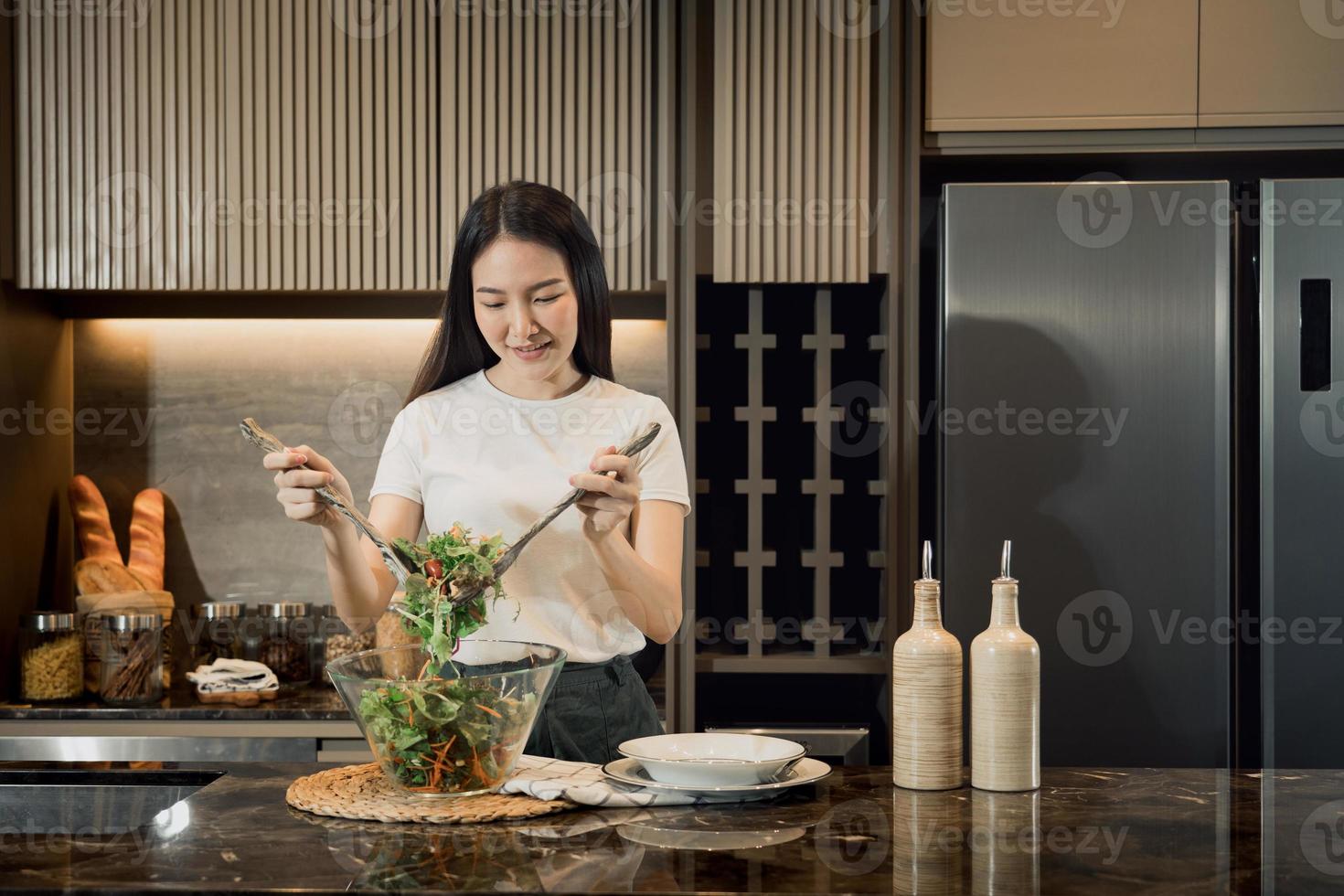 Aziatische huisvrouw die verse groenten voorbereidt om salade te maken thuis aanrecht. foto