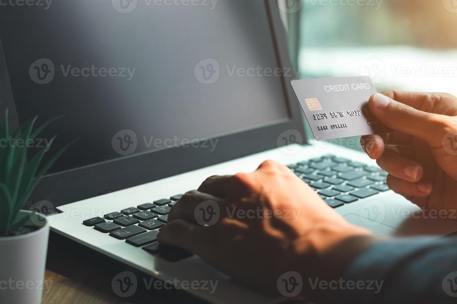 zakenman hand met creditcard met het gebruik van laptop voor online winkelen terwijl het maken van bestellingen thuis. business, lifestyle, technologie, e-commerce, digitaal bankieren en online betalingsconcept. foto
