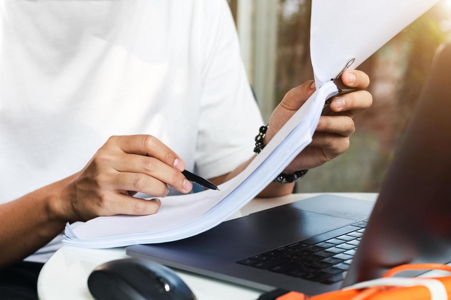 aziatische mannen werken aan hun bureau met notitieboekjes die aantekeningen maken en bestellingen accepteren van online klanten, online zaken en e-commerce, online winkels die producten verkopen. foto