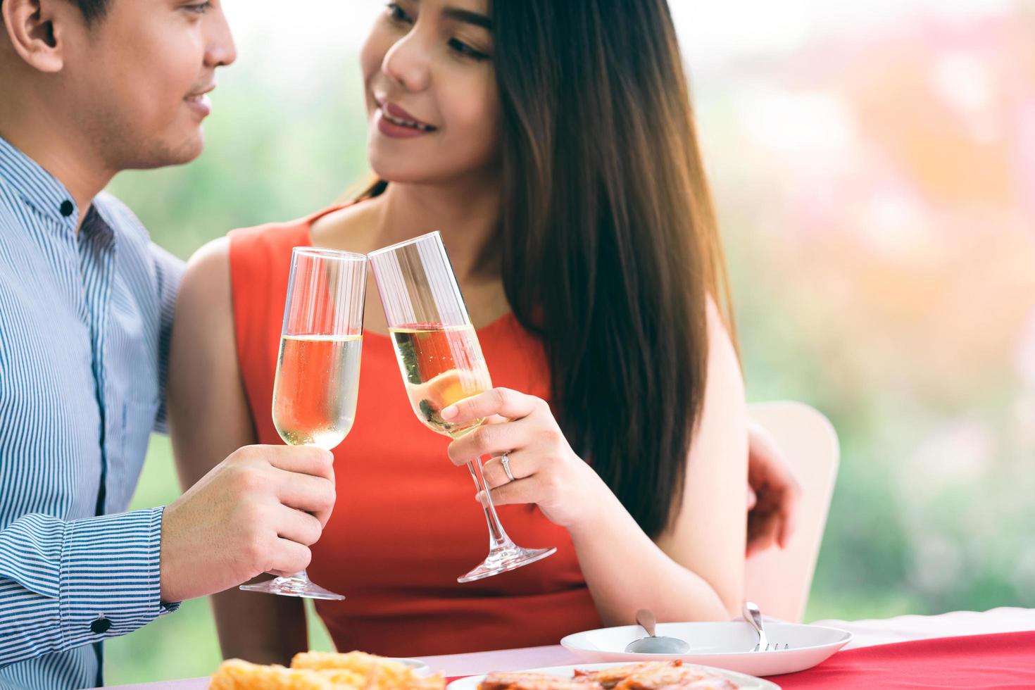 glimlach aziatische minnaar paar man en vrouw hand houden een champagne drankje en juichen. foto