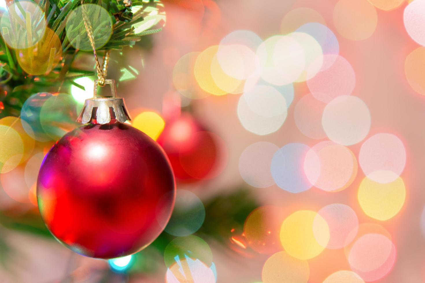 kerst decoratie. rode ballen hangen aan dennentakken kerstboom slinger en ornamenten over abstracte bokeh achtergrond met kopie ruimte foto