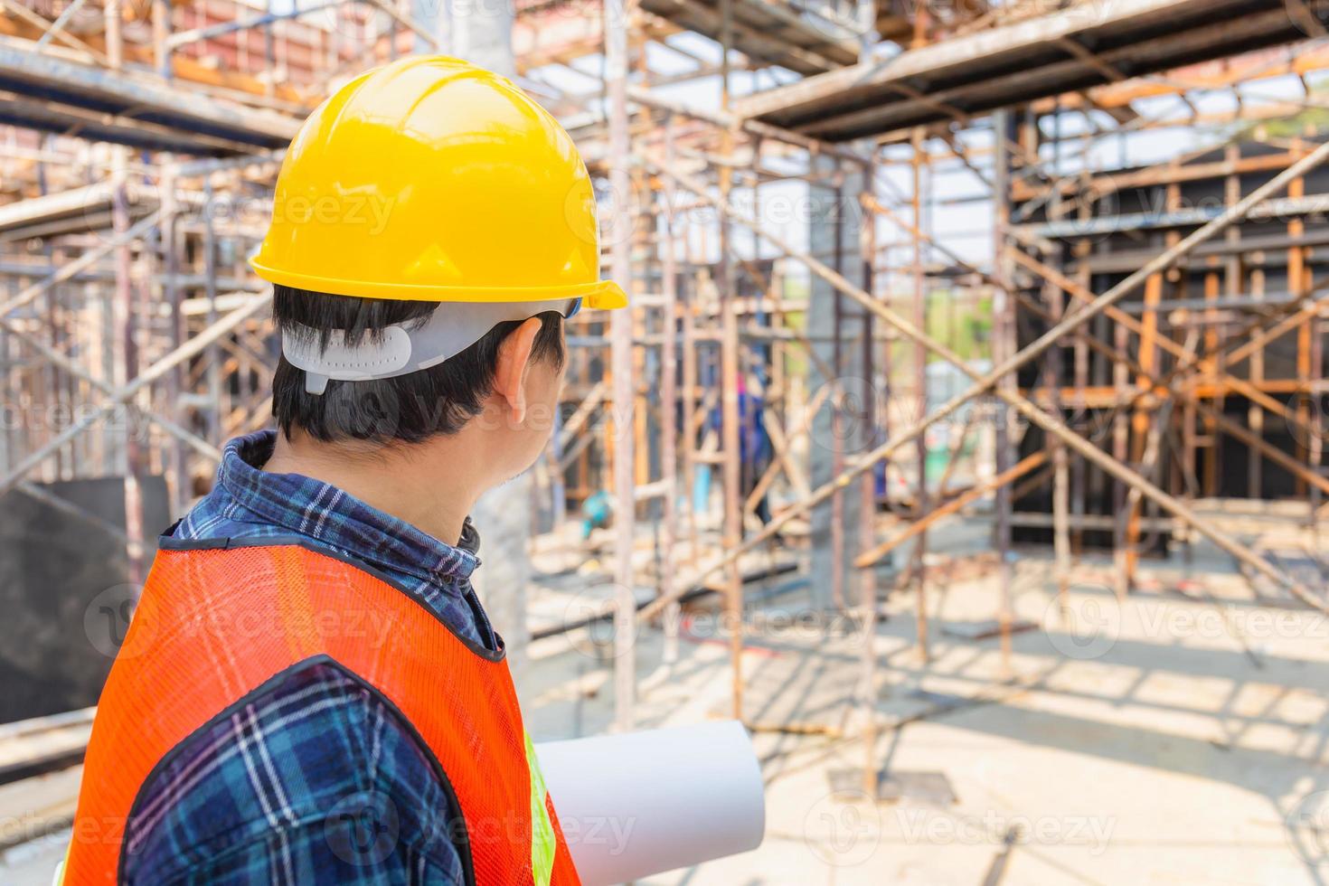 ingenieur voorman controleren en plannen van project op bouwplaats, man met blauwdruk met onscherpe achtergrond foto