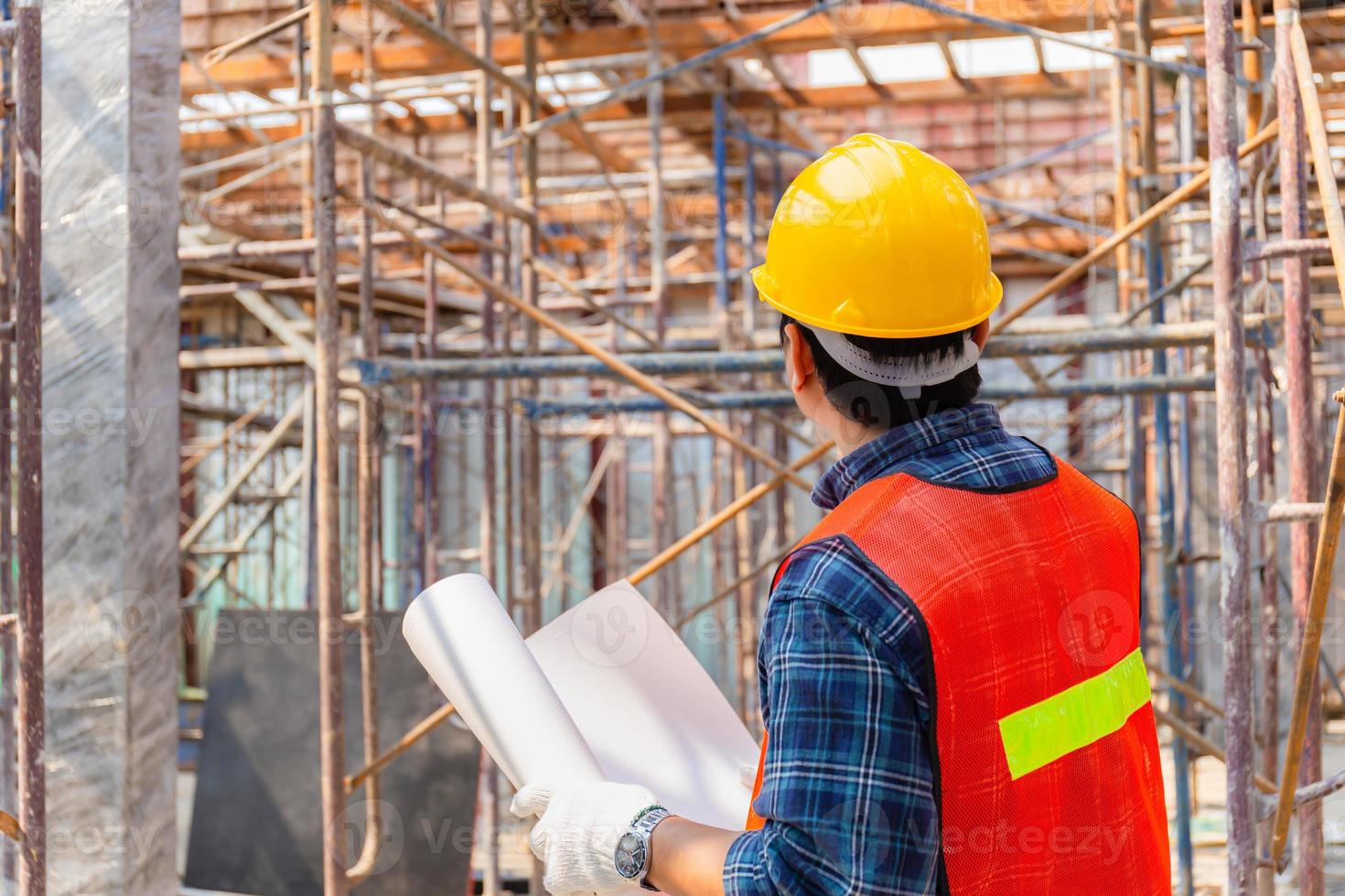 ingenieur man die project controleert en plant op de bouwplaats, man met blauwdruk selectieve focus op papier foto