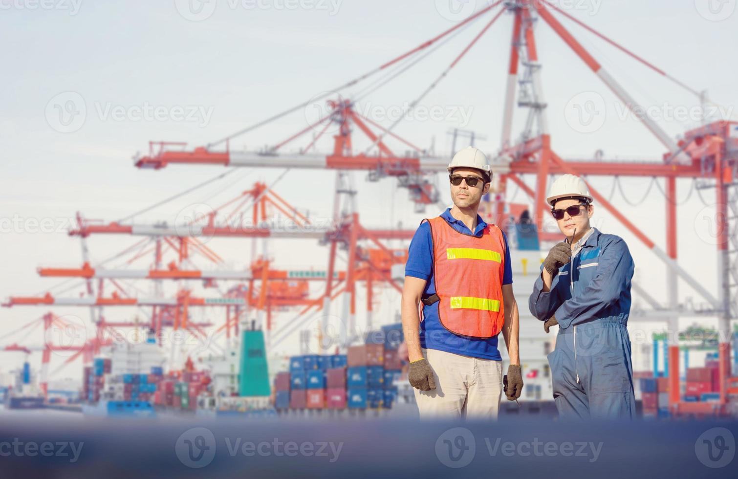 Ingenieur en arbeider man in veiligheidshelm en veiligheidsvest controleren controle laadcontainers doos van lading, teamwork concept foto