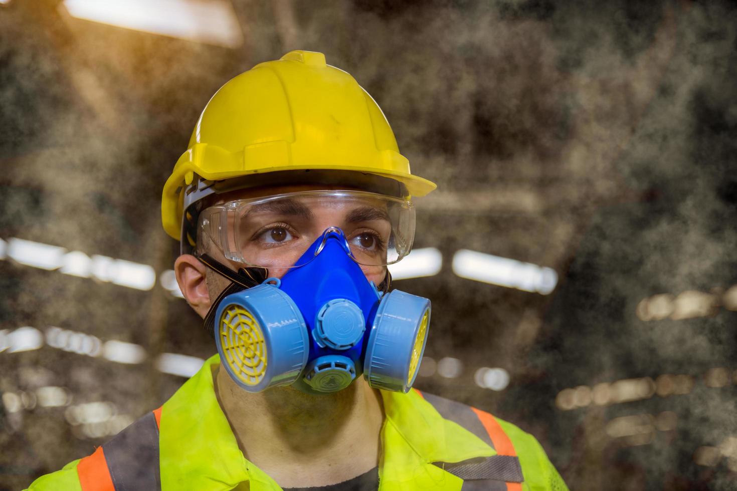 ingenieursindustrie die veiligheidsuniform draagt, zwarte handschoenen, gasmasker voelt stikken bij het controleren van chemische tank in fabriekswerk in de industrie. foto