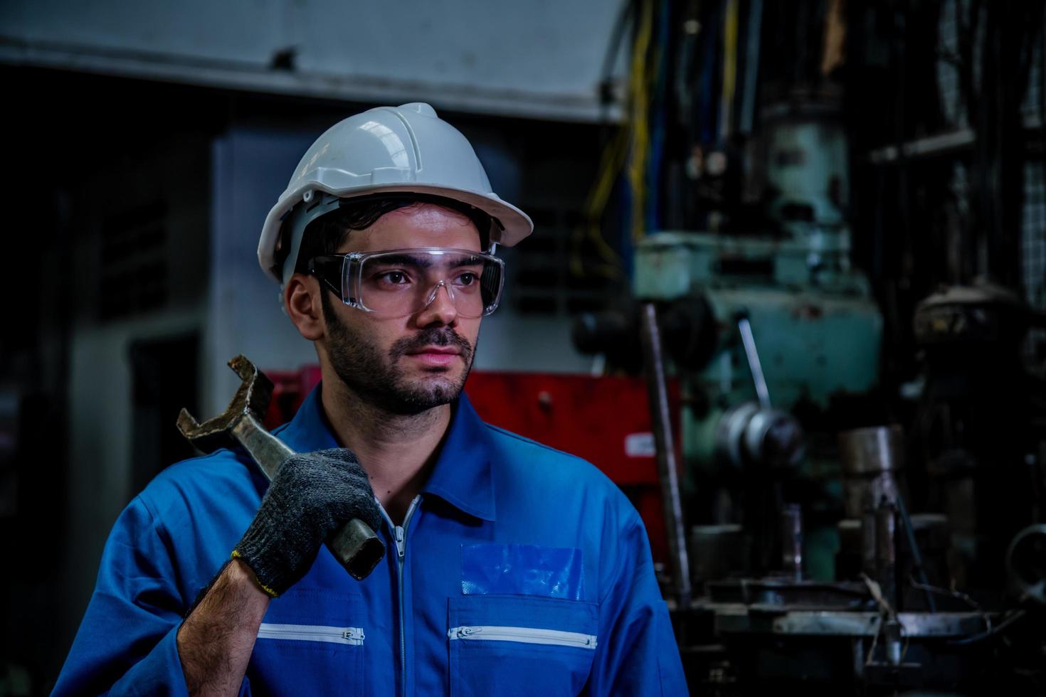 industrie engineering dragen veiligheid uniforme controle werkende draaibank slijpmachine werken in industrie fabriek. foto